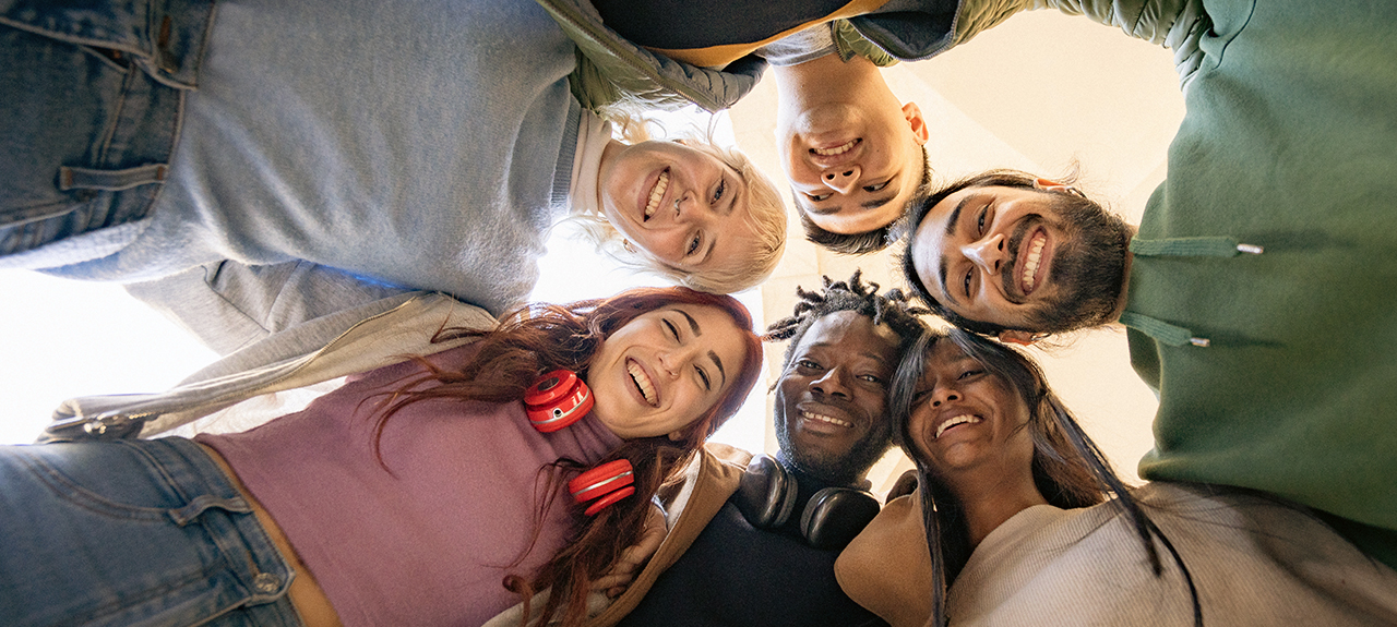 Diverse group of youth huddled above camera